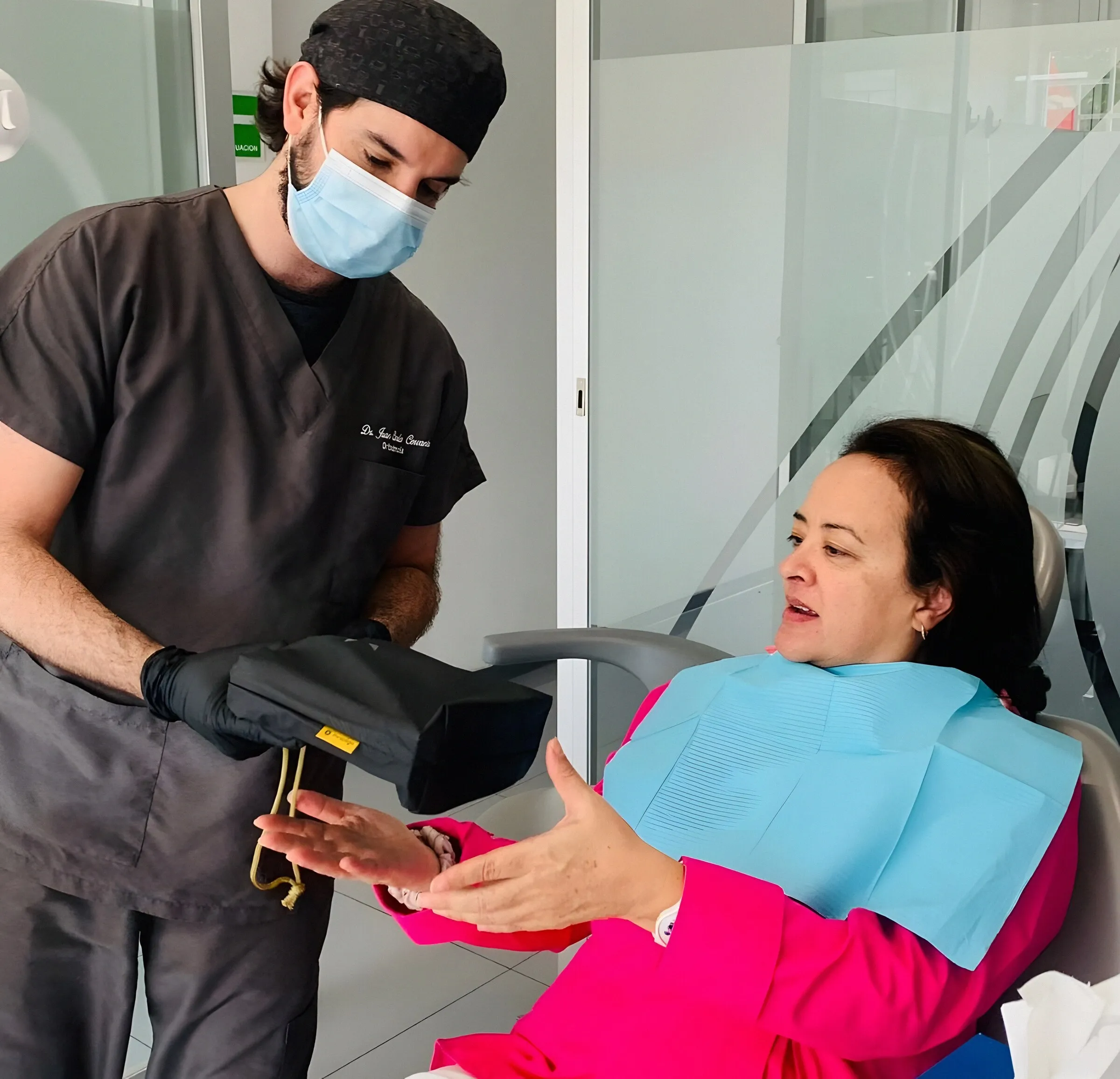 Dentista mostrando a una paciente en el sillón las imágenes de la cámara intraoral