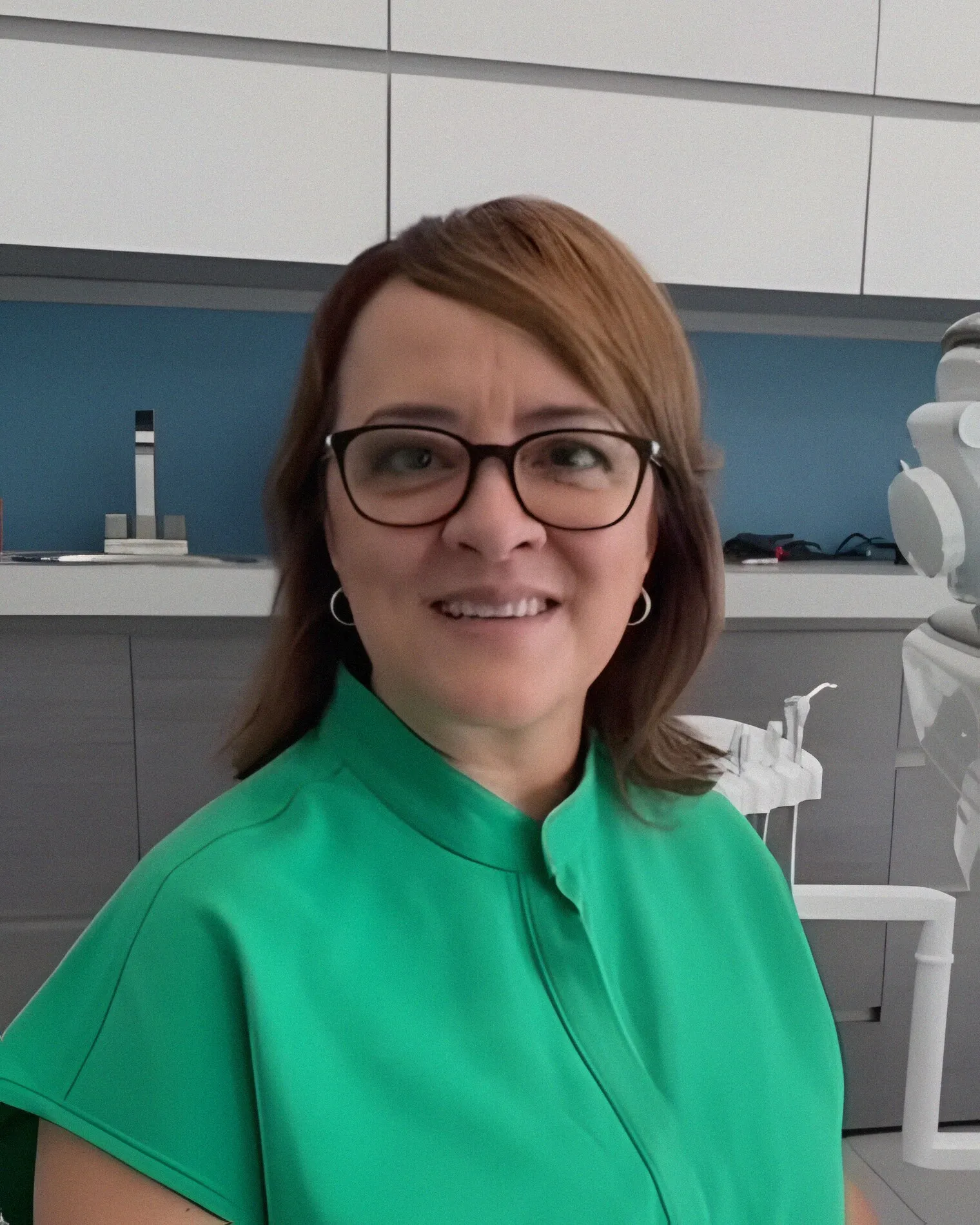 Retrato de la Dra. Lourdes Carrillo con uniforme verde en el consultorio